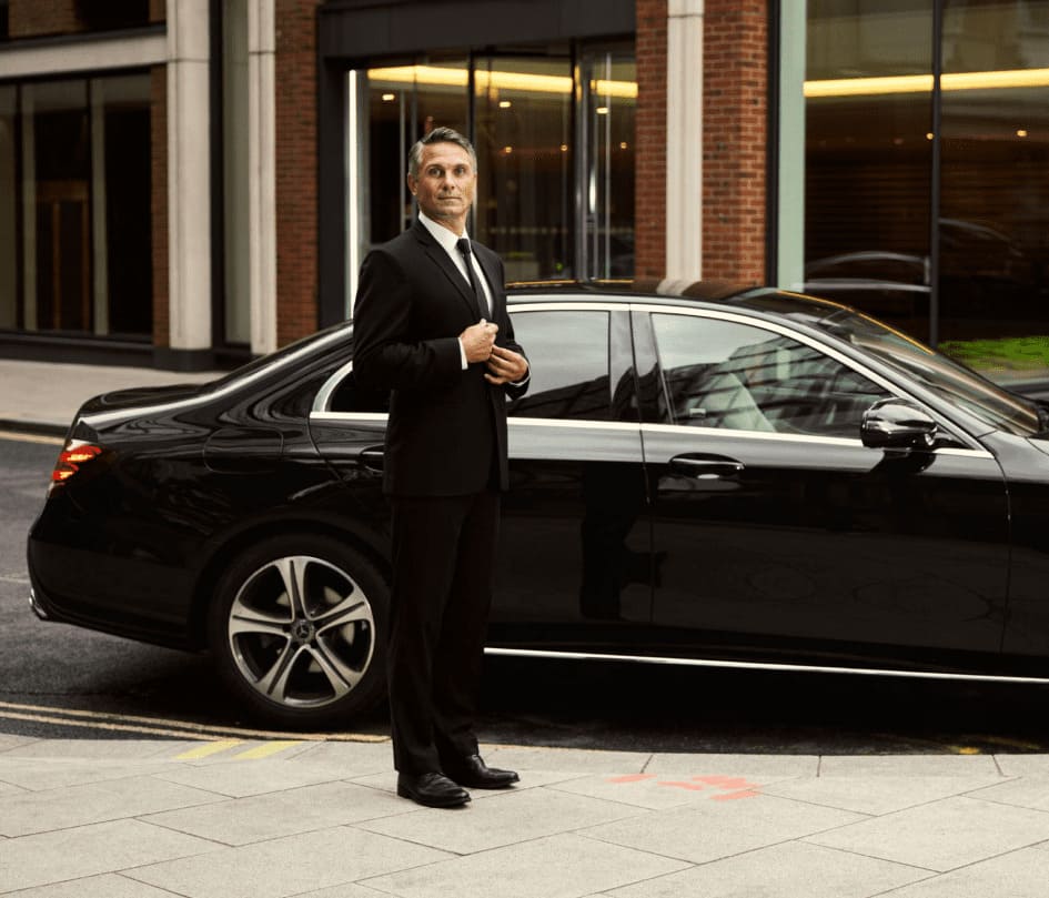 Professional chauffeur standing beside a luxury limo in Chicago