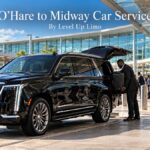 O'Hare to Midway car service with a black 2026 Cadillac Escalade and chauffeur loading a traveler's suitcase at an airport terminal curb